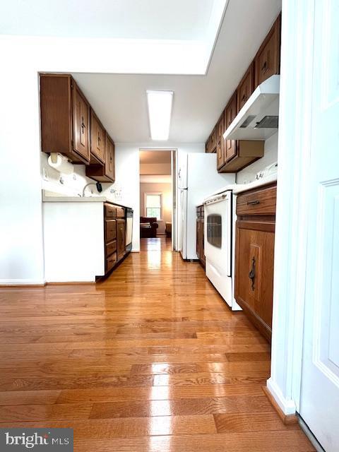 5044 Head Ct, Fairfax, VA 22032 - kitchen with under cabinet range hood, light countertops, light wood-style floors, range, and electric range