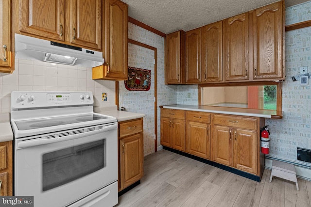 20 Hollow Rd, Levittown, PA 19056 - kitchen featuring white electric range oven, under cabinet range hood, light wood-style flooring, brown cabinetry, and a textured ceiling