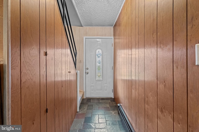 20 Hollow Rd, Levittown, PA 19056 - entryway with wood walls, stone tile flooring, a textured ceiling, and a baseboard radiator