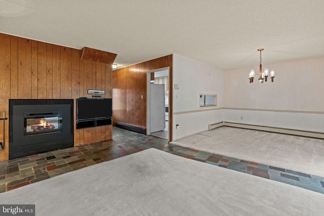 20 Hollow Rd, Levittown, PA 19056 - kitchen featuring wood walls, baseboard heating, a chandelier, a glass covered fireplace, and a textured ceiling
