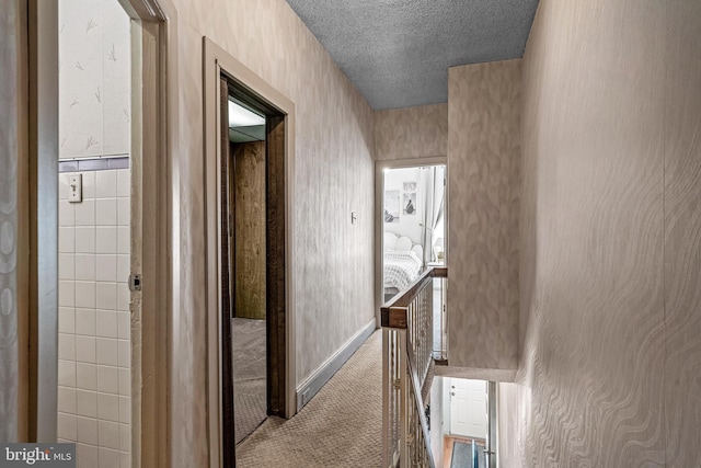 hall with carpet and a textured ceiling