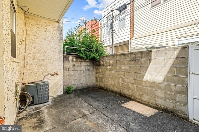view of home's exterior with central air condition unit, fence, and a patio area