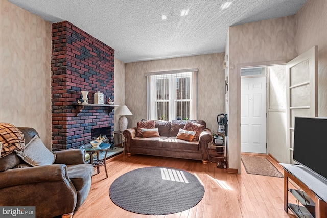 living area featuring hardwood / wood-style flooring, a textured ceiling, and a fireplace