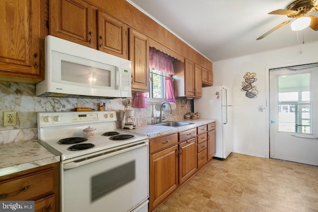 kitchen with white appliances, a sink, and brown cabinets