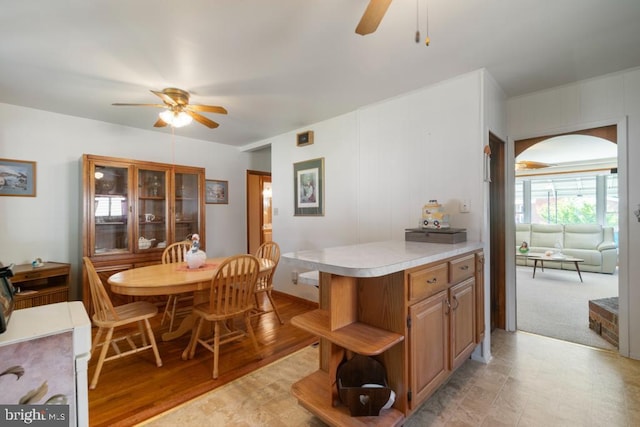 dining room with a ceiling fan and arched walkways