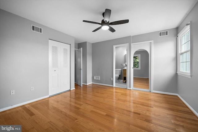 4559 Airlie Way, Annandale, VA 22003 - unfurnished bedroom featuring arched walkways, multiple windows, wood finished floors, and baseboards
