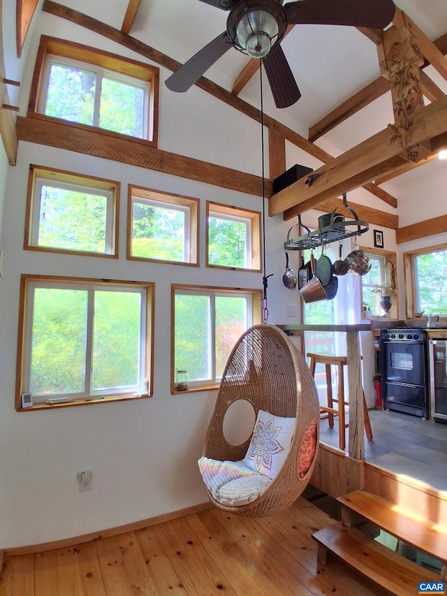 sitting room featuring baseboards, wood-type flooring, ceiling fan, beamed ceiling, and high vaulted ceiling