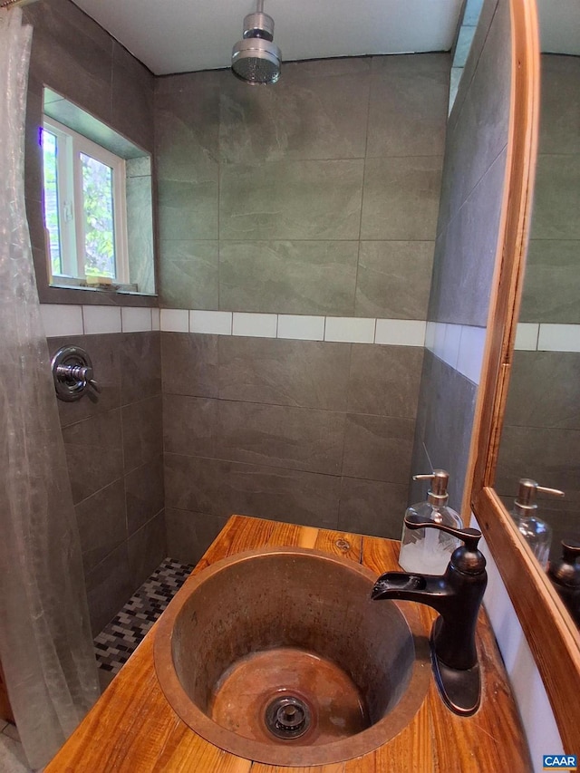 bathroom with tiled shower, a bathtub, and a sink