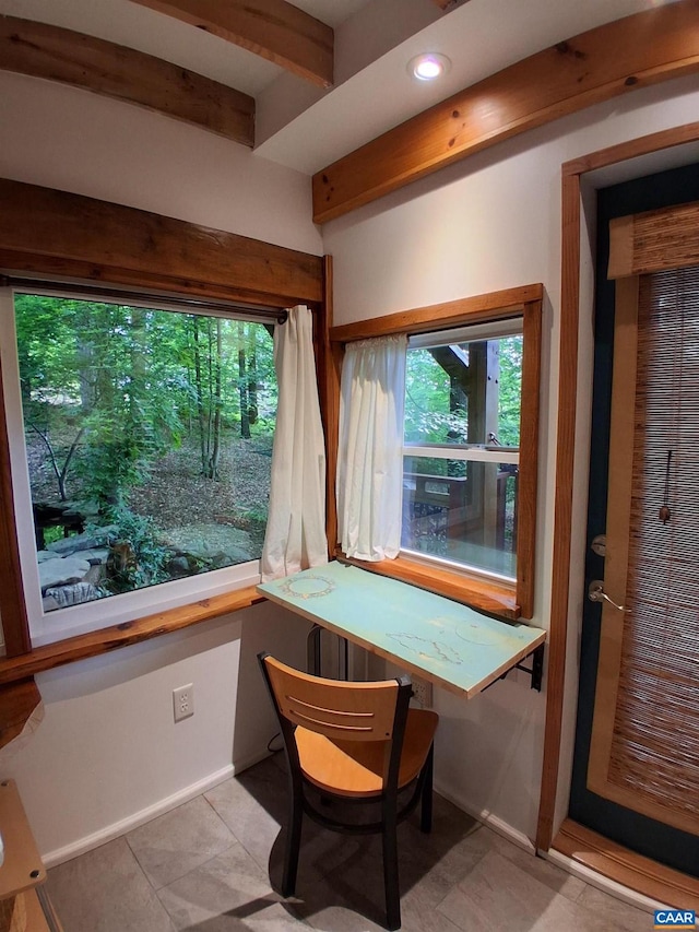 interior space featuring beam ceiling, tile patterned floors, and baseboards