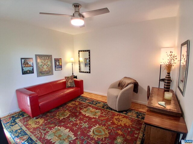 living area featuring ceiling fan and baseboards