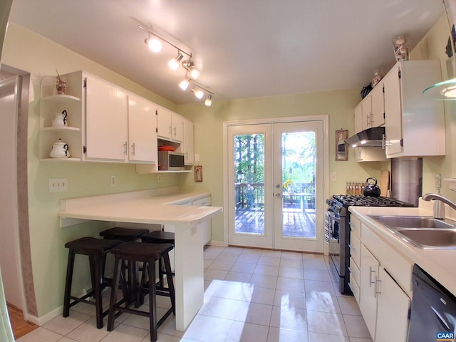 kitchen featuring under cabinet range hood, appliances with stainless steel finishes, french doors, a sink, and white cabinetry