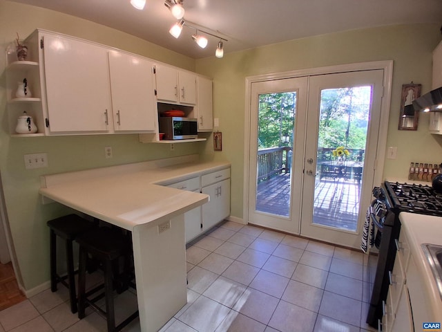 kitchen with stainless steel microwave, black gas stove, french doors, a peninsula, and open shelves