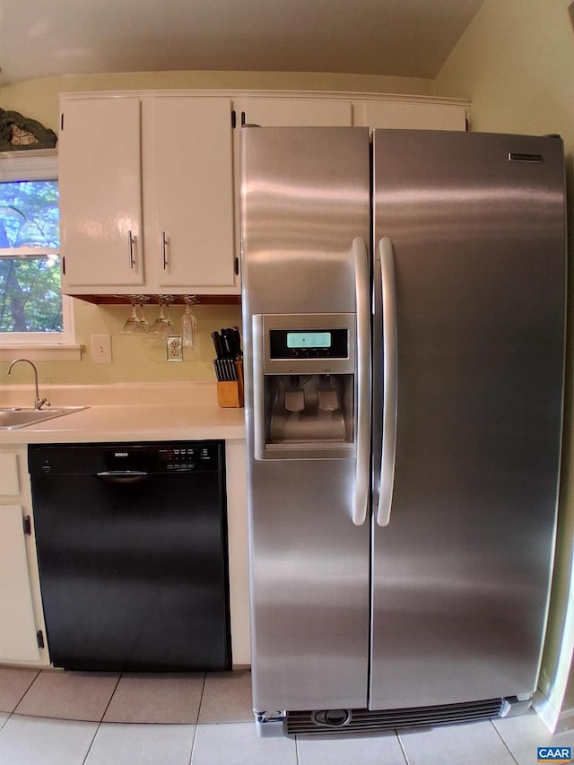 kitchen with stainless steel fridge with ice dispenser, black dishwasher, a sink, light countertops, and light tile patterned floors