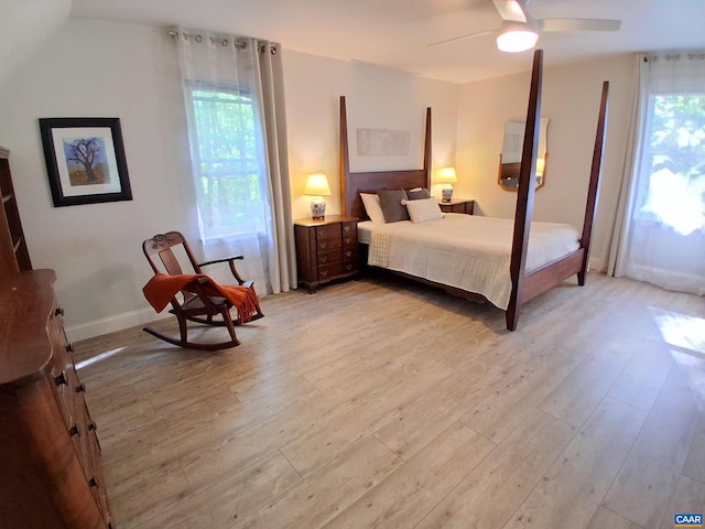 bedroom with light wood-style flooring, multiple windows, and baseboards