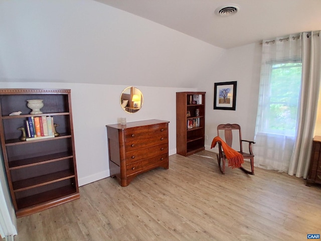 sitting room with light wood-style floors, lofted ceiling, and baseboards