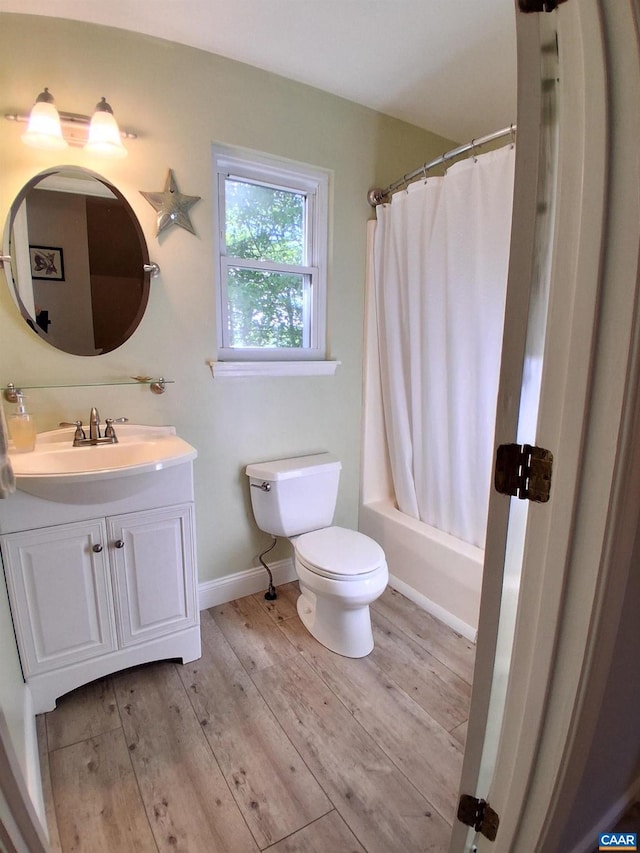 full bath with wood finished floors, toilet, vanity, baseboards, and shower / bath combination with curtain