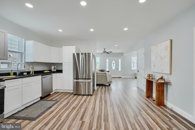 kitchen featuring stainless steel appliances, a sink, plenty of natural light, baseboards, and recessed lighting