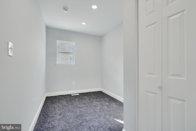empty room featuring dark colored carpet, baseboards, recessed lighting, and a smoke detector