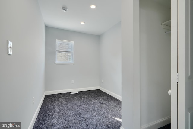 spare room with dark colored carpet, a smoke detector, baseboards, and recessed lighting