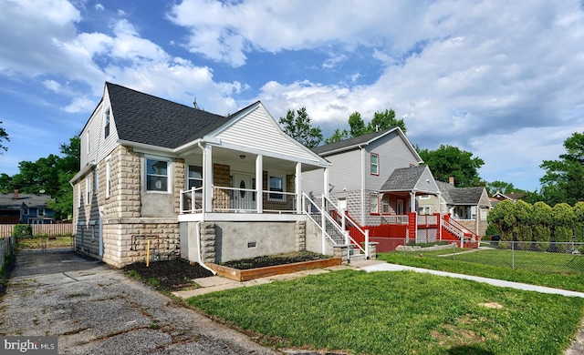 bungalow-style house featuring stone siding, a porch, stairs, roof with shingles, and driveway