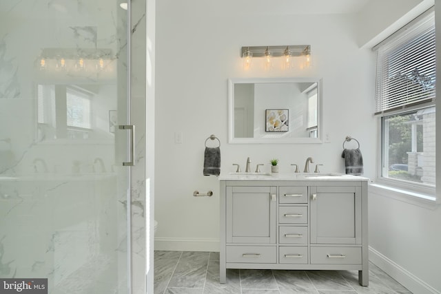 bathroom with baseboards, marble look tiles, a marble finish shower, and double vanity