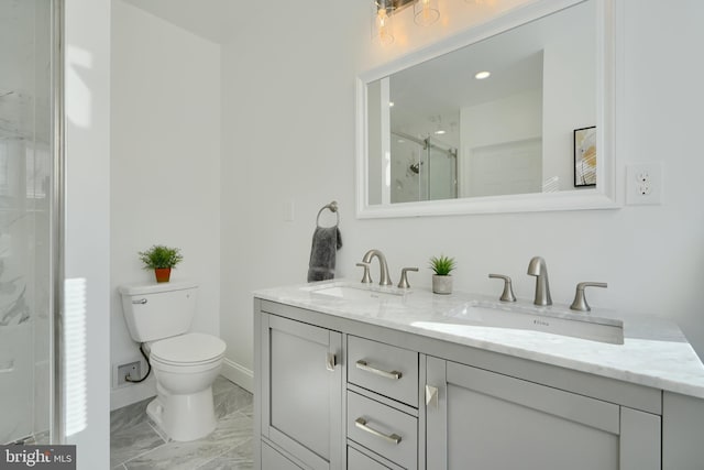 full bath with marble look tiles, a marble finish shower, toilet, double vanity, and baseboards