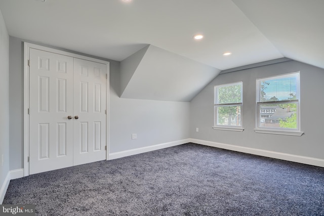 additional living space with baseboards, dark colored carpet, recessed lighting, and lofted ceiling