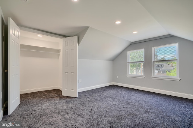additional living space featuring dark colored carpet, vaulted ceiling, baseboards, and recessed lighting