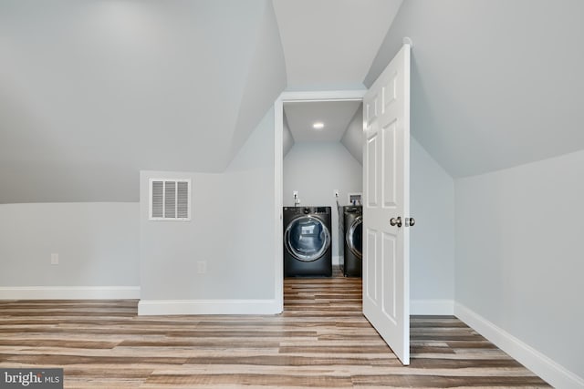 laundry room featuring wood finished floors, independent washer and dryer, and baseboards
