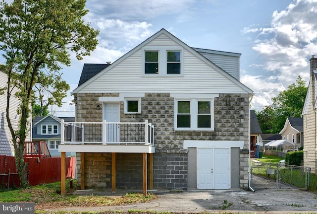 back of house featuring fence and stone siding