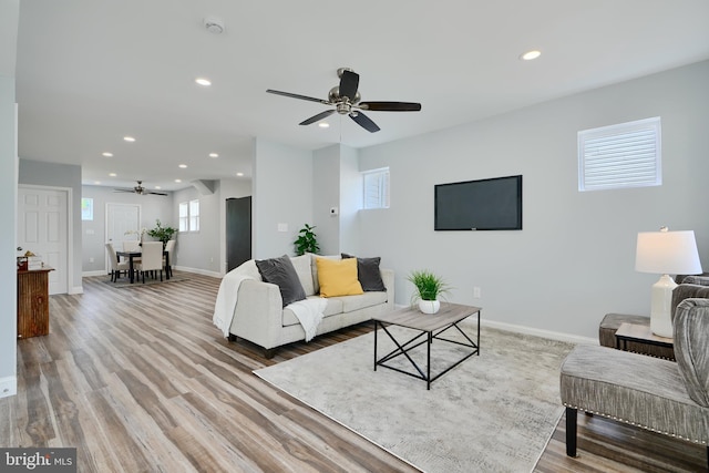 living area with ceiling fan, recessed lighting, baseboards, and light wood-type flooring