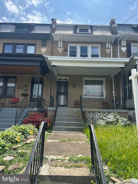 632 Farragut St NW, Washington, DC 20011 - view of property featuring mansard roof, brick siding, and a porch