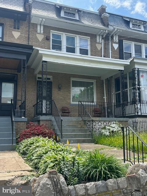 632 Farragut St NW, Washington, DC 20011 - property entrance featuring brick siding, mansard roof, covered porch, and a high end roof