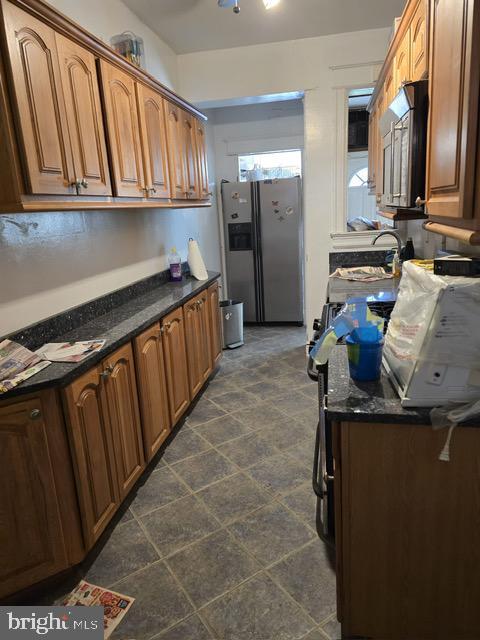 632 Farragut St NW, Washington, DC 20011 - kitchen featuring appliances with stainless steel finishes, brown cabinets, and dark stone countertops