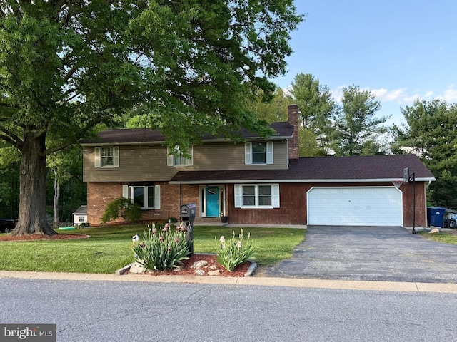 traditional home featuring a chimney, an attached garage, asphalt driveway, and a front lawn