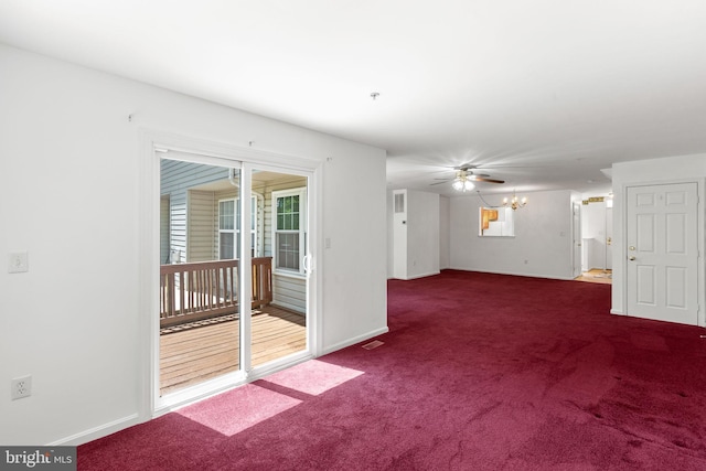 carpeted spare room with baseboards, ceiling fan, and a chandelier