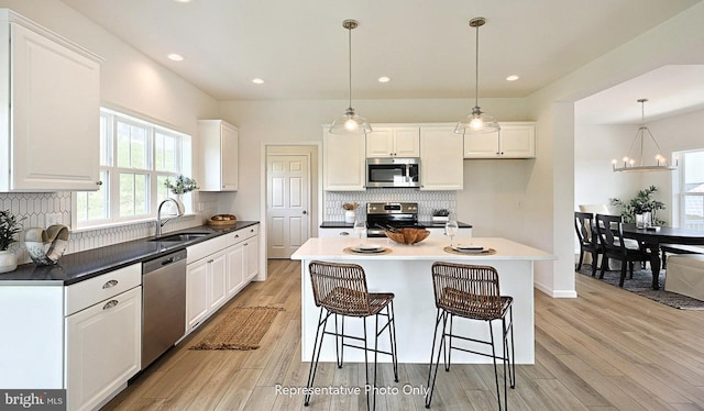 416 Allegheny Dr, Mechanicsburg, PA 17055 - kitchen with stainless steel appliances, a sink, light wood-style floors, white cabinets, and backsplash