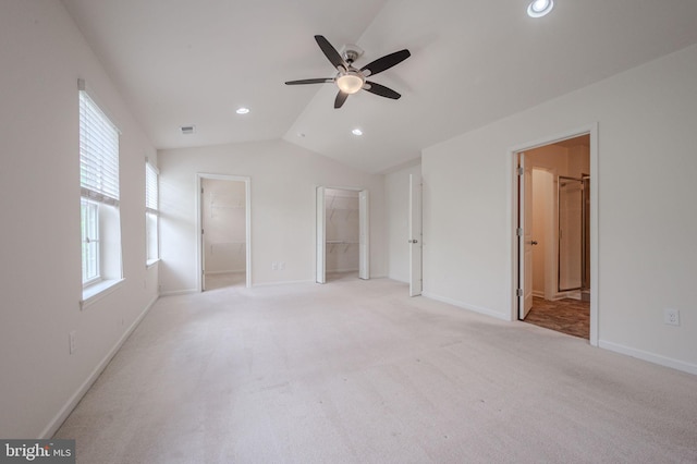 unfurnished bedroom featuring vaulted ceiling, a spacious closet, recessed lighting, light carpet, and baseboards
