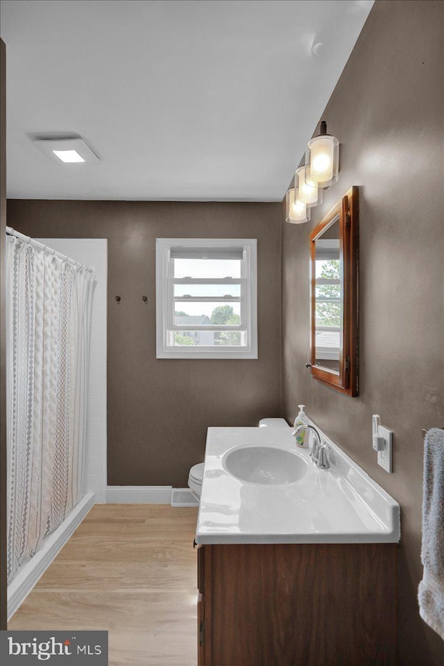 full bathroom featuring wood finished floors, vanity, baseboards, toilet, and a shower with shower curtain