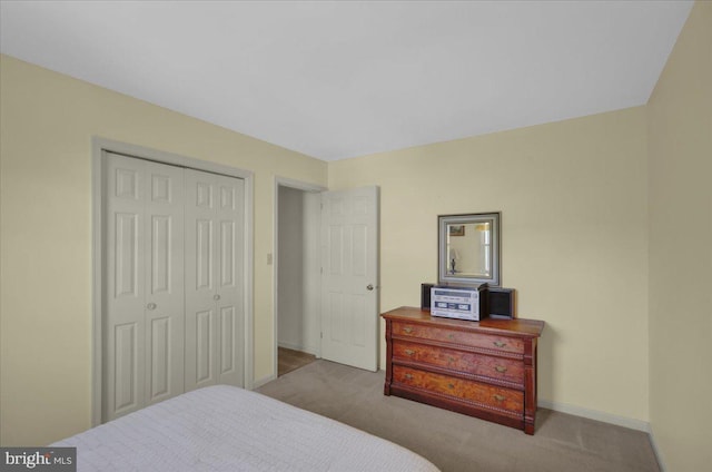 carpeted bedroom with baseboards and a closet