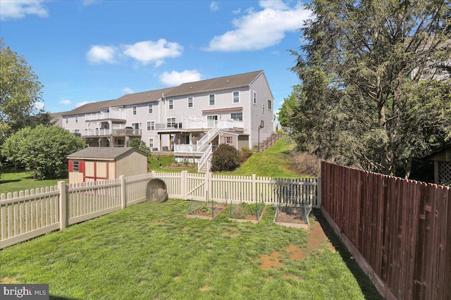 view of yard featuring a vegetable garden, an outbuilding, and a residential view