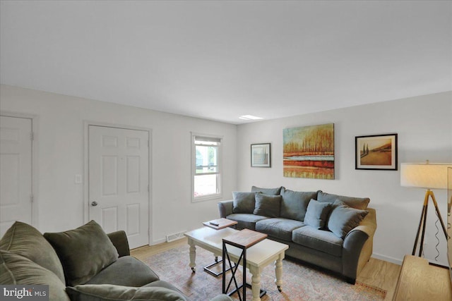 living room with light wood-type flooring and baseboards