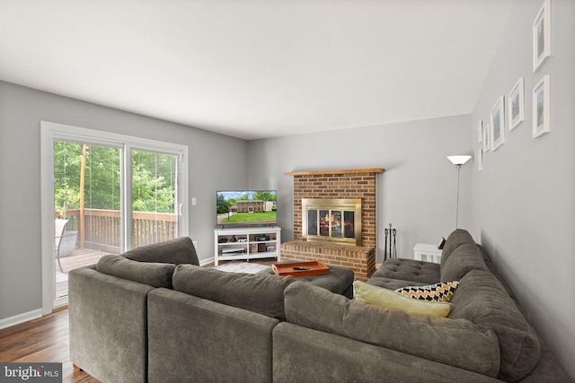 living area featuring dark wood-style flooring, baseboards, and a fireplace