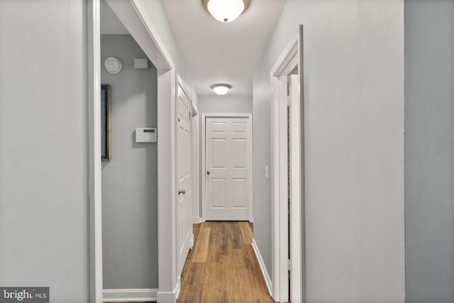 hall featuring wood finished floors and baseboards