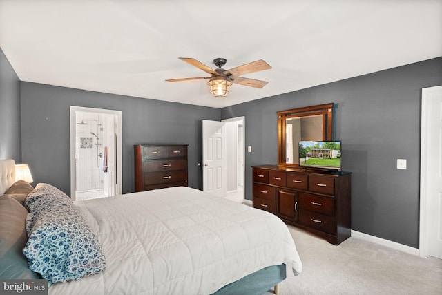 bedroom with light colored carpet, baseboards, ceiling fan, and ensuite bathroom