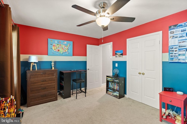 carpeted bedroom with ceiling fan and a closet