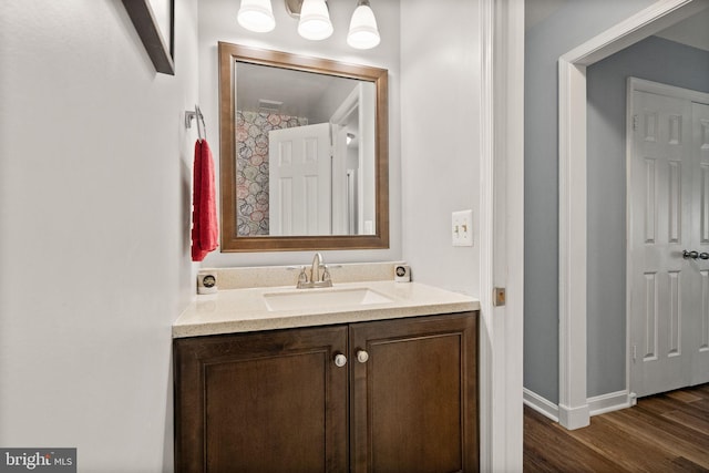 bathroom featuring wood finished floors, vanity, and baseboards
