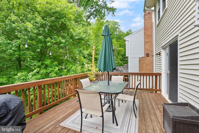 deck featuring outdoor dining area and a grill