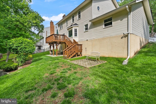 rear view of house with a patio area, stairs, a wooden deck, and a yard