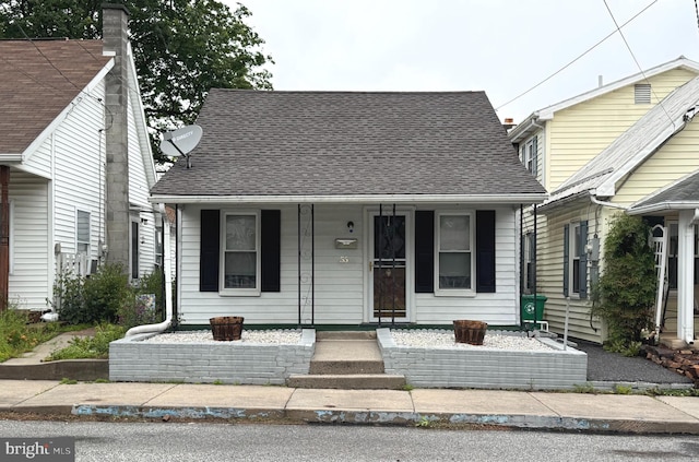 bungalow-style house with a shingled roof and a porch
